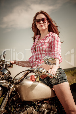 Biker girl sitting on motorcycle