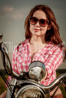 Biker girl sitting on motorcycle