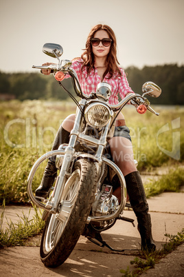 Biker girl sitting on motorcycle