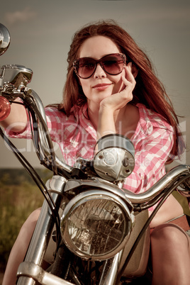 Biker girl sitting on motorcycle