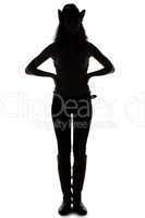 Silhouette of young cowgirl - hands on waist