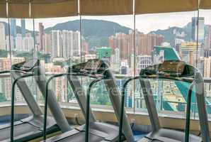 Gym with city view through wall glasses