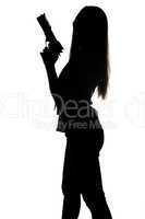 Silhouette of young woman with gun