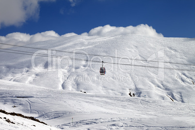 Gondola lift and ski slope at sun day