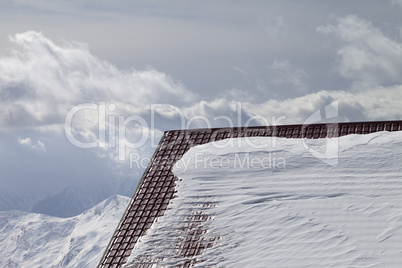 Roof of hotel in snow and winter mountains