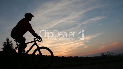 Mountainbiker fährt vorbei im Sonnenuntergang