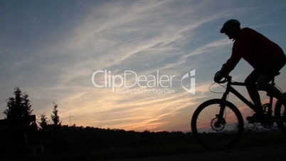 Mountainbiker fährt vorbei im Sonnenuntergang