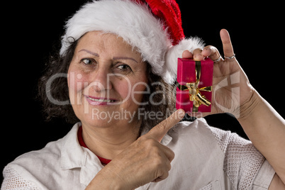 Smiling Aged Woman Holding and Pointing at Red Gift.