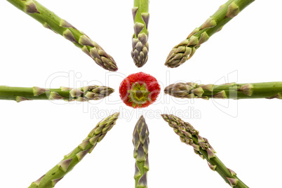 Eight Asparagus Spears Pointing at One Strawberry