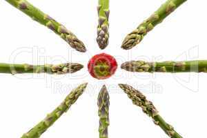 Eight Asparagus Spears Pointing at One Strawberry