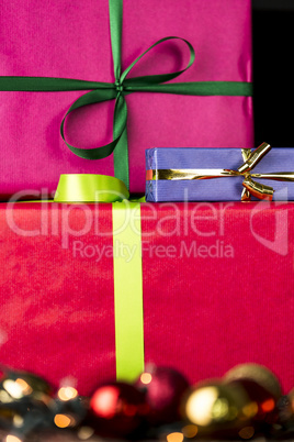 Three wrapped gifts, bowknots, spheres and glitters.