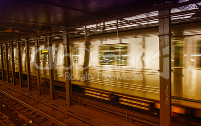 Silver Train speeding up on a subway station interior