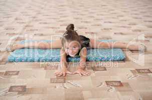 Little girl doing leg-split on the floor