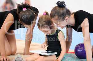 Three gymnast girls with tablet computer