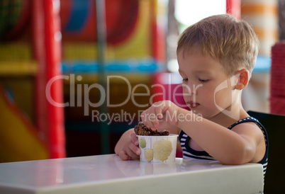 Little child eating chocolate ice cream