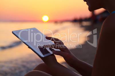 Woman using pad outdoor at sunset