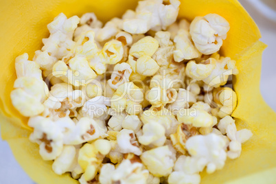 Tasty popcorn in yellow paper bag