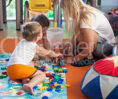 Doing puzzle with tutor in nursery
