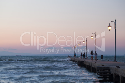 People walking along the pier in evening