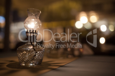 Antique oil lamp with dim light on table in cafe