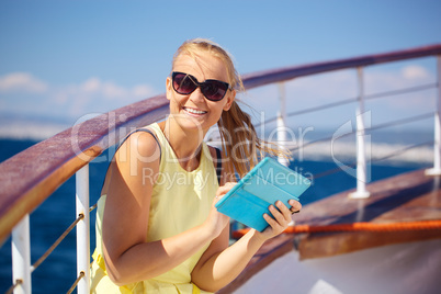 Happy woman with pad during sea traveling