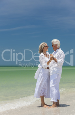 Happy Senior Couple Dancing Holding Hands on Beach