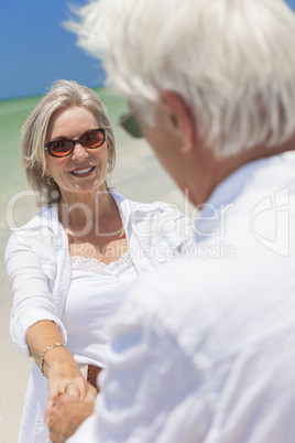 Happy Senior Couple Dancing Holding Hands on Beach