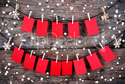 Red Tags with Copy Space Hanging in the Snow on Wooden Background