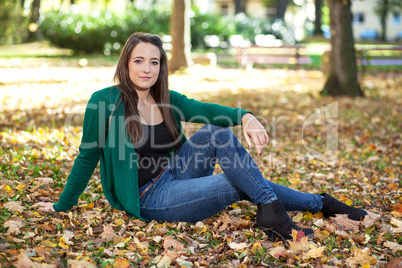 Woman sitting in autumn leaves