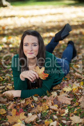 Woman lying in autumnal park