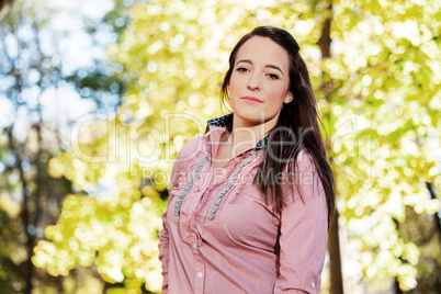 Woman with long hair standing in front of yellow autumn tree