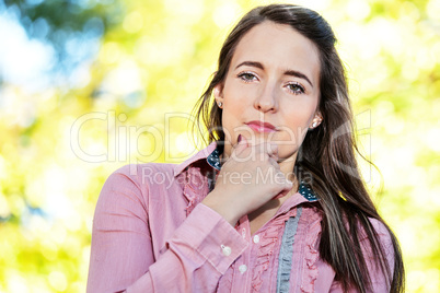 Woman with long hair standing in front of yellow autumn tree