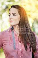 Woman with long hair standing in front of yellow autumn tree