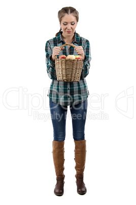 Photo of woman looking at basket with apples