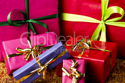 Six Bows Tied around Unicolored Gift Boxes.