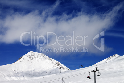 Chair-lift and ski slope at sun day