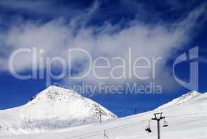 Chair-lift and ski slope at sun day