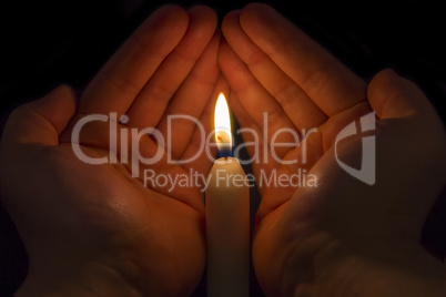 Hands protecting a Candle