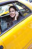 Young Woman Talking on Cell Phone in Yellow Taxi
