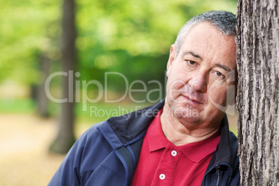 Emotion Loser man leaning against tree