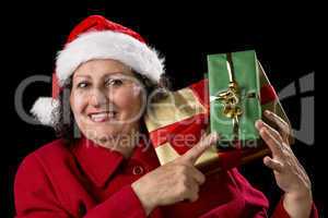 Senior Lady with Santa Cap Points at Wrapped Gifts.