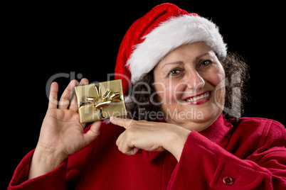 Happy Old Woman with Red Cap Points at Xmas Gift.