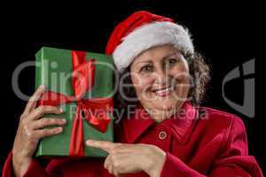 Happy Female Pensioner Pointing at Wrapped Gift.