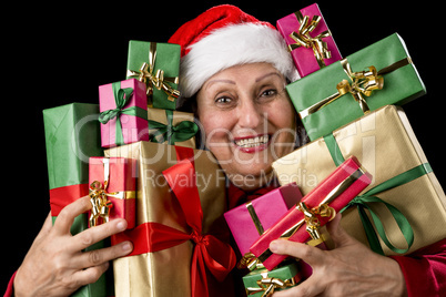 Delighted Old Lady Hugging a Dozen Wrapped Gifts.