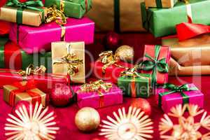 Numerous Xmas Gifts Arranged on a Red Cloth