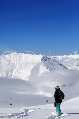 Snowboarder on off-piste slope with new fallen snow at nice day