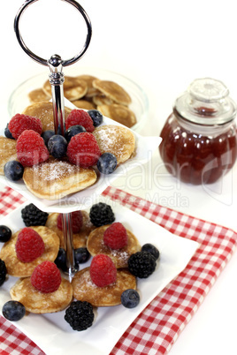 Poffertjes mit Beeren und Gelee auf einer Etagere