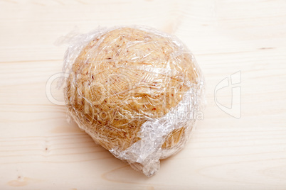 Ready shaped dough ball wrapped in plastic wrap