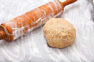 Wooden rolling pin and a dough ball