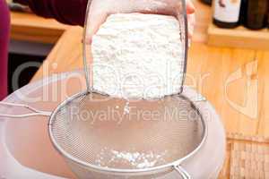 Put flour of glass bowl through a flour sieve